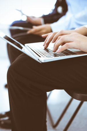 Group of business people working in office, close-up. Businesswoman typing on laptop. Conference,...