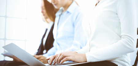 Group of business people working in office, close-up. Businesswoman typing on laptop. Conference, training or meeting conceptsの写真素材