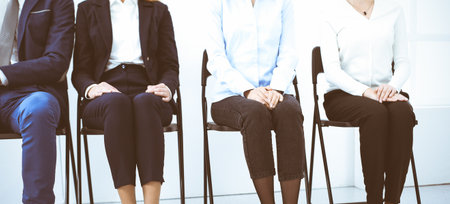Group of business people sitting in office and waiting for job interview while using gadgets, close-up. Recruiting and headhunting conceptsの写真素材