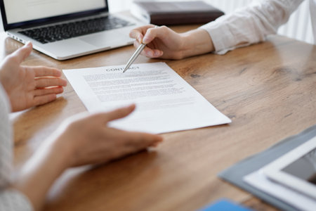 Business people discussing contract signing deal while sitting at the wooden table in office. Partners or lawyers working together at meeting. Teamwork, partnership, success conceptの写真素材