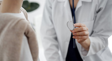 Doctor and a kid patient. Physician is holding stethoscope and ready to examine boy. Perfect health concept in medicineの写真素材