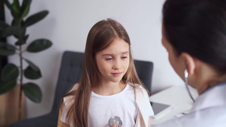 Doctor and patient. Unhappy child girl is at usual medical inspection in clinic. Medicine conceptの写真素材