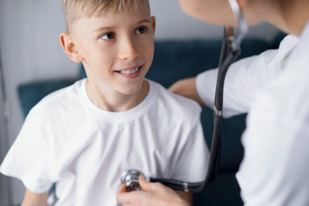 Happy smiling child patient at usual medical inspection. Doctor and kid boy at home. Medicine, healthcare conceptsの写真素材