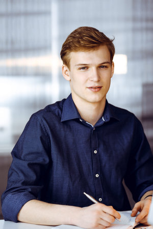 Young blond businessman working with computer. Startup business means working hard and out of time...