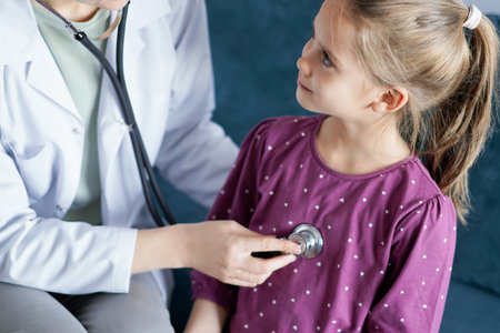 Happy smiling child patient at usual medical inspection. Doctor and kid patient at home. Medicine, healthcare conceptsの写真素材