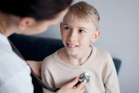 Doctor and happy smiling child boy patient at home medical inspection. Medicine, healthcare concepts