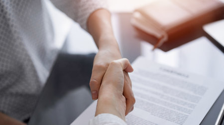 Business people signing contract papers while sitting at the glass table in office, closeup. Partners or lawyers working together at meeting. Teamwork, partnership, success conceptの写真素材