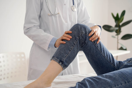 Doctor and patient are at the usual medical inspection in the clinic. Therapist examines a young womans knee. Medicine conceptの写真素材