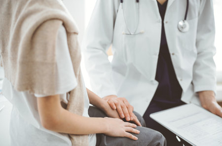 Doctor and child patient. The physician is holding clipboard and reassuring a boy. The concept of ideal health in medicineの写真素材