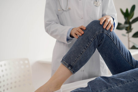 Doctor and patient are at the usual medical inspection in the clinic. Therapist examines a young womans knee. Medicine conceptの写真素材