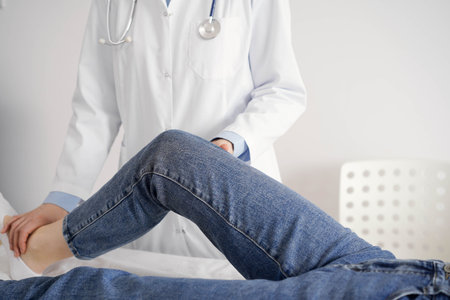 Doctor and patient are at the usual medical inspection in the clinic. Therapist examines a young womans knee. Medicine conceptの写真素材
