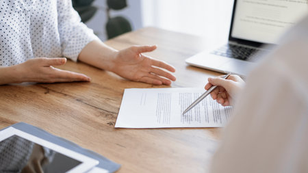 Business people discussing contract signing deal while sitting at the wooden table in office. Partners or lawyers working together at meeting. Teamwork, partnership, success conceptの写真素材