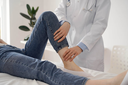 Doctor and patient are at the usual medical inspection in the clinic. Therapist examines a young womans knee. Medicine conceptの写真素材