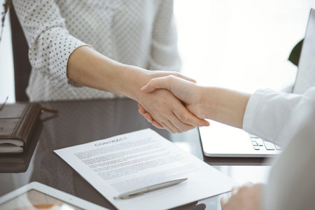 Business people signing contract papers while sitting at the glass table in office, closeup....