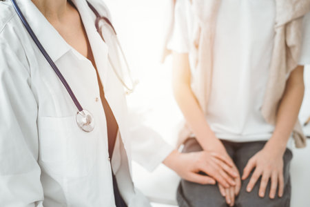 Doctor and child patient. The physician is holding clipboard and reassuring a boy. The concept of ideal health in medicineの写真素材