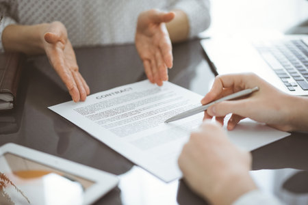Businesswoman lawyer pointing into contract special points admitting something for colleague or client at meeting. Business people teamwork and partnershipの写真素材