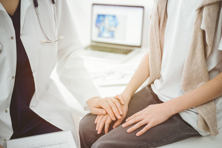 Doctor and child patient. The physician is holding clipboard and reassuring a boy. The concept of ideal health in medicineの写真素材