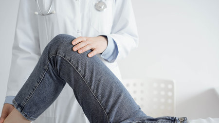 Doctor and patient are at the usual medical inspection in the clinic. Therapist examines a young...