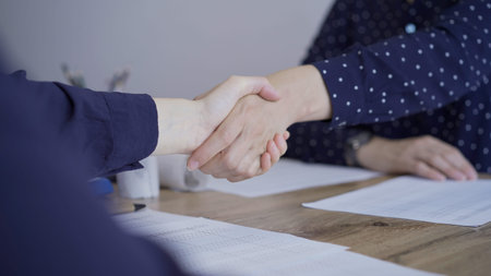 Accountants or auditors shaking hands after reviewing financial