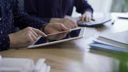 Accountants or auditors reviewing financial documents while sitting at the wooden desk in office....