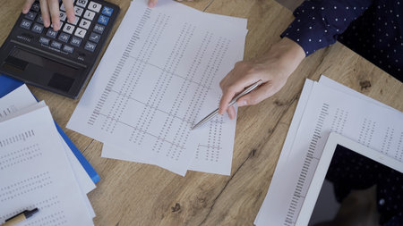 Accountants or auditors reviewing financial documents while sitting at the wooden desk in office....