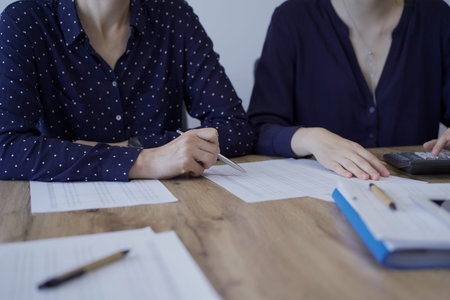 Accountants or auditors reviewing financial documents while sitting at the wooden desk in office....