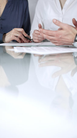 Business people are reviewing contract terms during a meeting, negotiating and making decisions together, vertical close up view. Copy space areaの写真素材