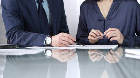 Business people reviewing contract terms during a meeting, negotiating and making decisions together. Business people concept, close upの写真素材