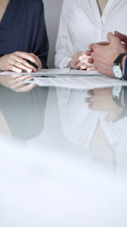 Business people are reviewing contract terms during a meeting, negotiating and making decisions together, vertical close up view. Copy space areaの写真素材