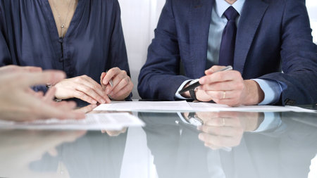 Business partners or lawyers are discussing contract papers during a meeting, negotiating and making decisions together. Business people concept, close upの写真素材