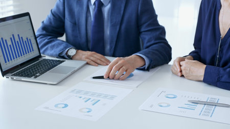 Business partners are discussing company performance and making plans based on charts and graphs...