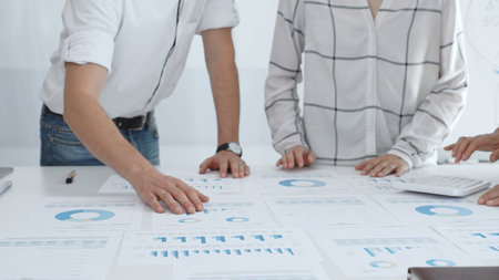 Business team collaborating in modern bright office, analyzing financial data, evaluating...