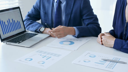 Business partners are discussing company performance and making plans based on charts and graphs...