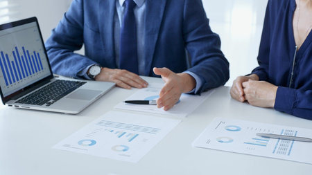 Business partners are discussing company performance and making plans based on charts and graphs...