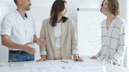 Professional team reviewing financial data, sharing success, collaborating around workplace...