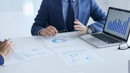 Businesspeople colleagues are reviewing financial data, analyzing charts and graphs, pointing at...