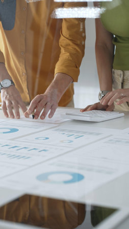 Two business professionals are collaborating on a project, analyzing financial charts and statistics...