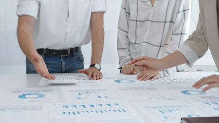 Group of business people is collaborating in modern office environment, analyzing financial data and...