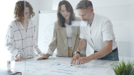Professional team reviewing financial data, collaborating on working documents, demonstrating team...