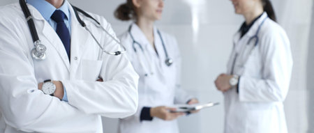 Medical team of doctors collaborating and consulting in a bright hospital setting, showcasing patient care, professionalism, and teamwork among healthcare workersの写真素材