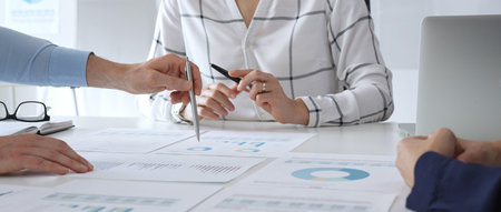 Business meeting with colleagues discussing financial charts, strategy planning, and analyzing data reports during a professional teamwork collaboration sessionの写真素材