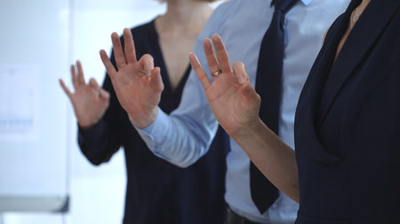 Business people showing ok gesture, affirming agreement, teamwork, and success, expressing satisfaction, approval, and support in a professional settingの写真素材