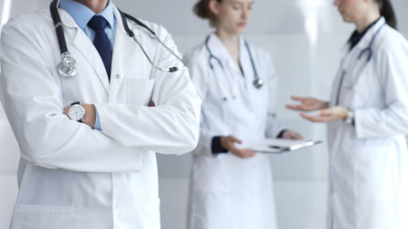 Doctors working together in a well-lit hospital environment, demonstrating patient care,...