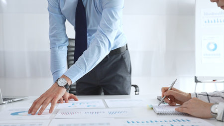 Business team analyzing financial charts and corporate data during strategy meeting, discussing...