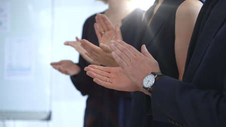 Group of business people clapping hands celebrating achievement, showing appreciation and support during a corporate meeting or seminar at a bright office conferenceの写真素材