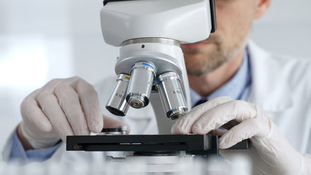Close up of male scientific researcher wearing white protective gloves carefully calibrating...