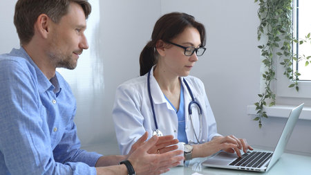 Female doctor consulting with patient in medical office, using laptop to provide healthcare advice and support while discussing treatment options in a professional setting. Medicine conceptの写真素材