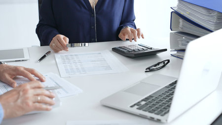 Business team of business man and female entrepreneur analyzing financial documents, using...
