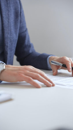 Businessman reviewing contract details, professional hands examining document before signing crucial...