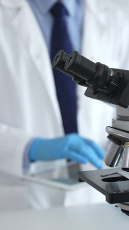 Microscope is on a table, ready for innovative medical research in a sterile laboratory environment....